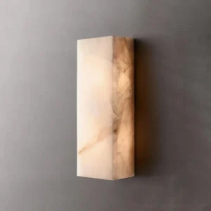 Rectangular alabaster wall sconce mounted on dark gray wall emitting warm ambient light stone texture detail