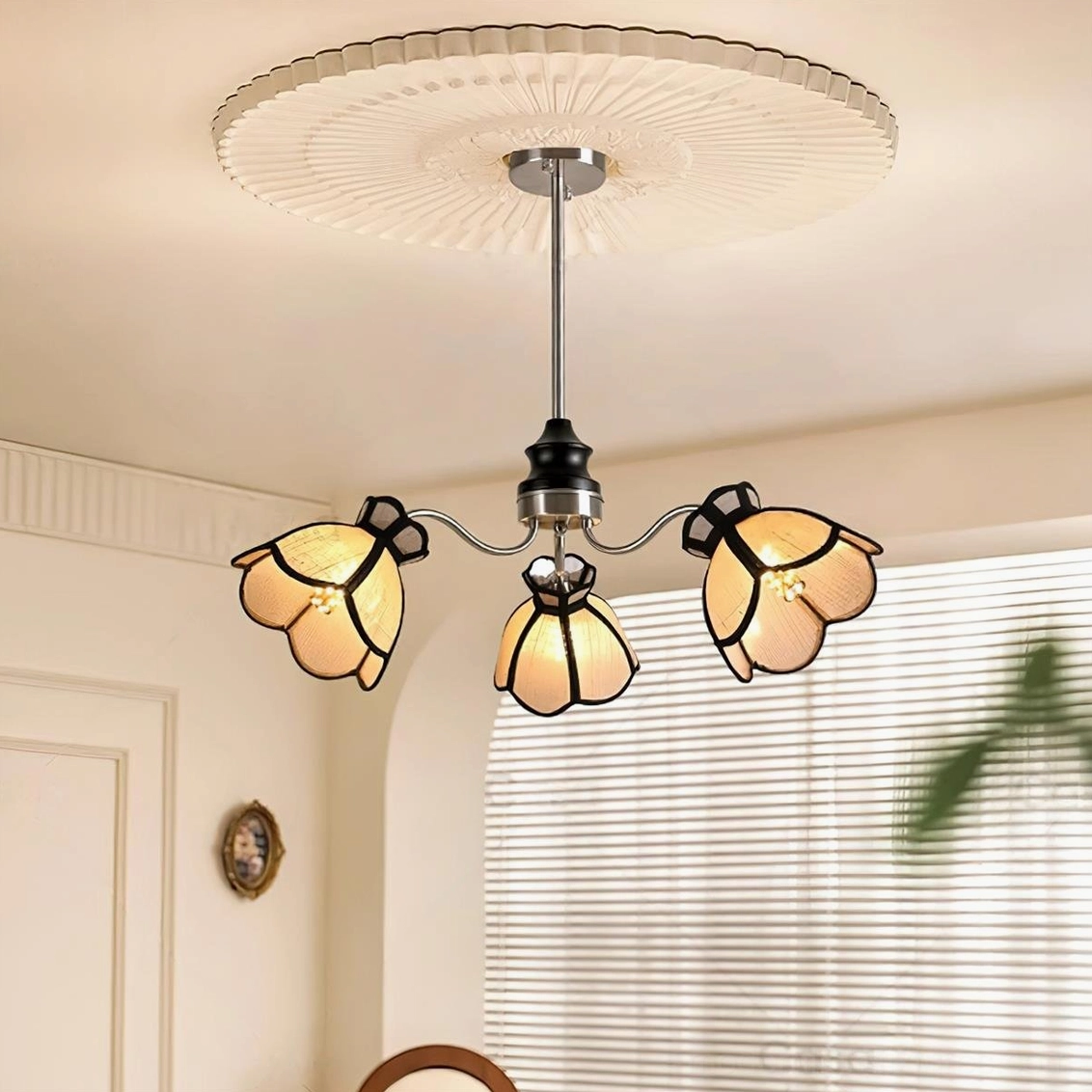 Low-angle upward view of 5-head flower chandelier in residential dining space with warm pleated ceiling rose
