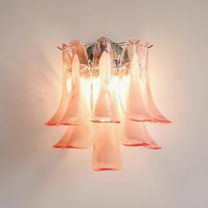 Illuminated Alrinis pink glass wall lamp glowing with warm amber light soft ambient lighting