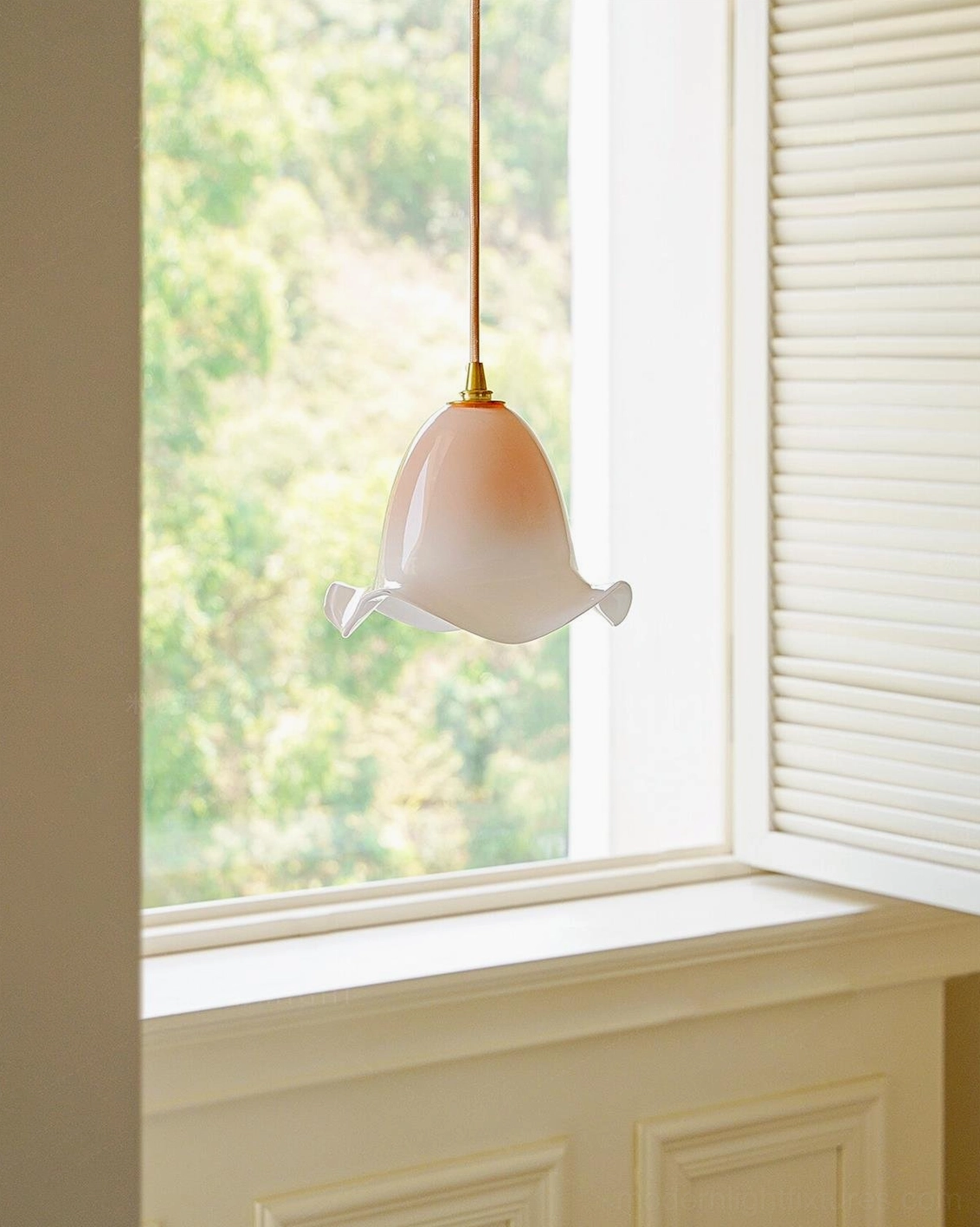 Aluna organic glass pendant light in soft pink, side interior view showing warm brass hardware and hanging cable