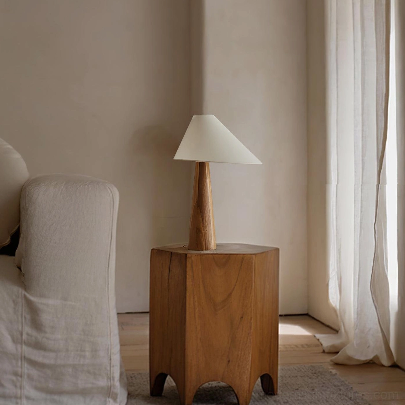 Alvin modern table lamp in cozy living room setting, placed on carved wooden side table with warm ambient lighting