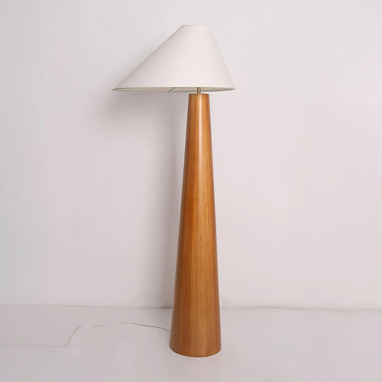 Natural wood floor lamp with off-white linen shade, left front view showing complete design with power cord and conical shade silhouette