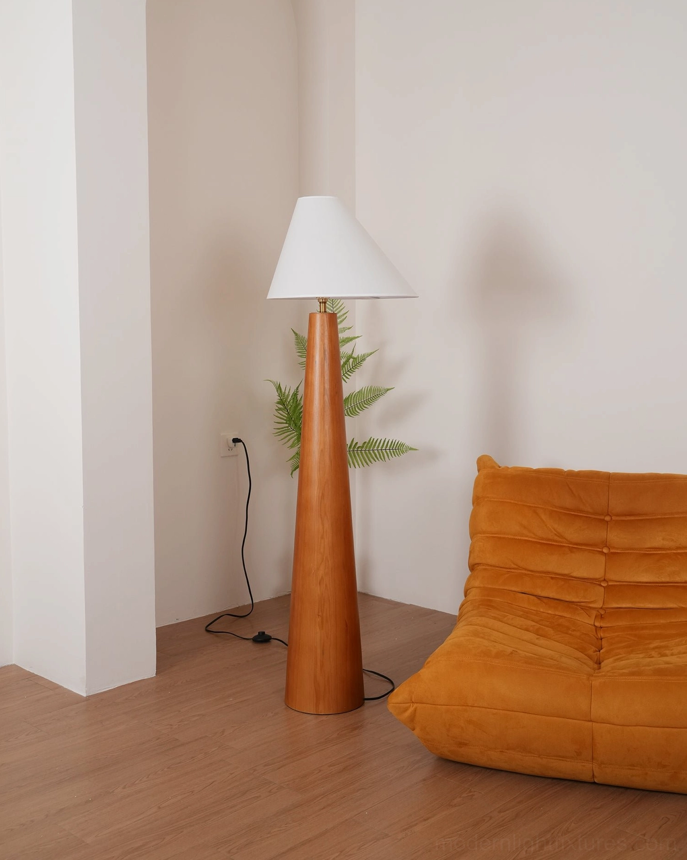 Contemporary Scandinavian floor lamp with tapered wood base and conical white linen shade in neutral minimalist interior setting