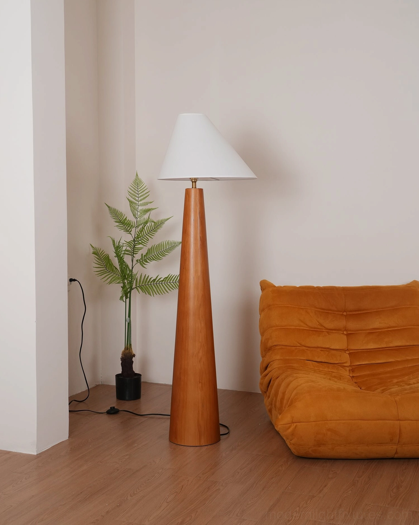Natural wood tapered floor lamp with off-white linen asymmetrical shade, left corner side view highlighting wood grain and fabric texture