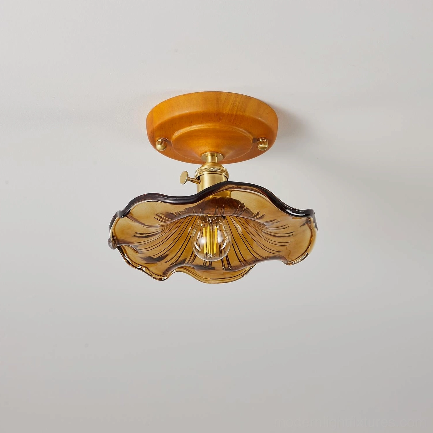 Amber flush mount ceiling light with wood canopy mounted on residential ceiling