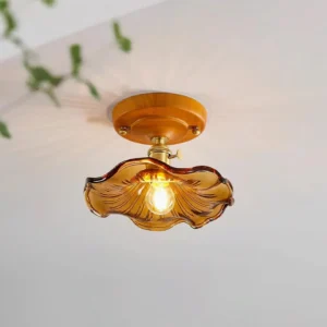 Warm amber wavy glass ceiling light fixture installed, casting soft ambient light with greenery decor