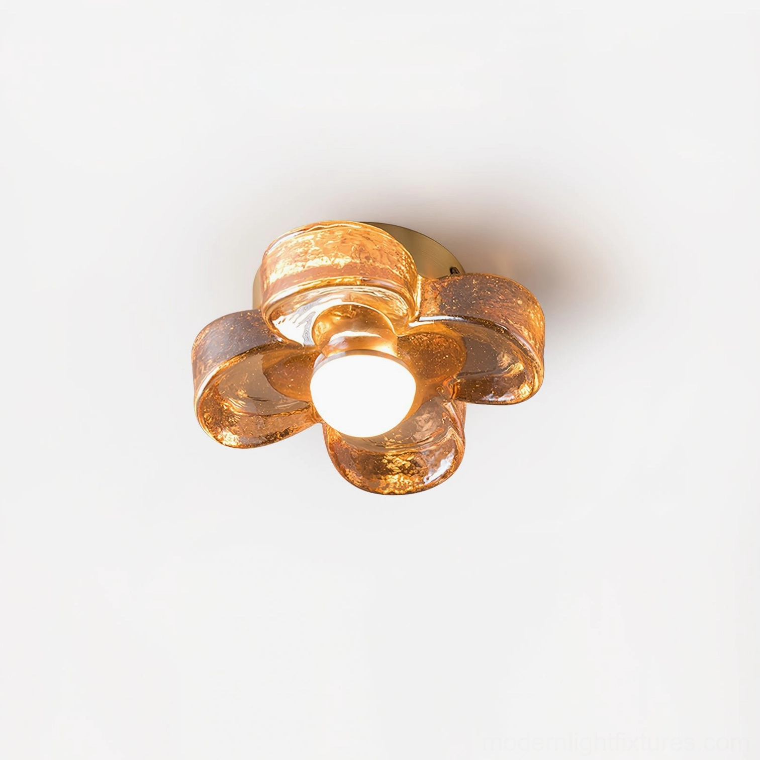 Three-quarter angle of four-leaf clover ceiling lamp with crackle amber glass petals and illuminated central LED bulb