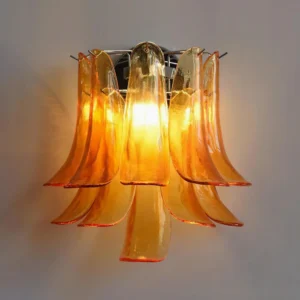 Amber flower petal wall sconce with illuminated warm interior glow, high angle view of glossy textured glass petals