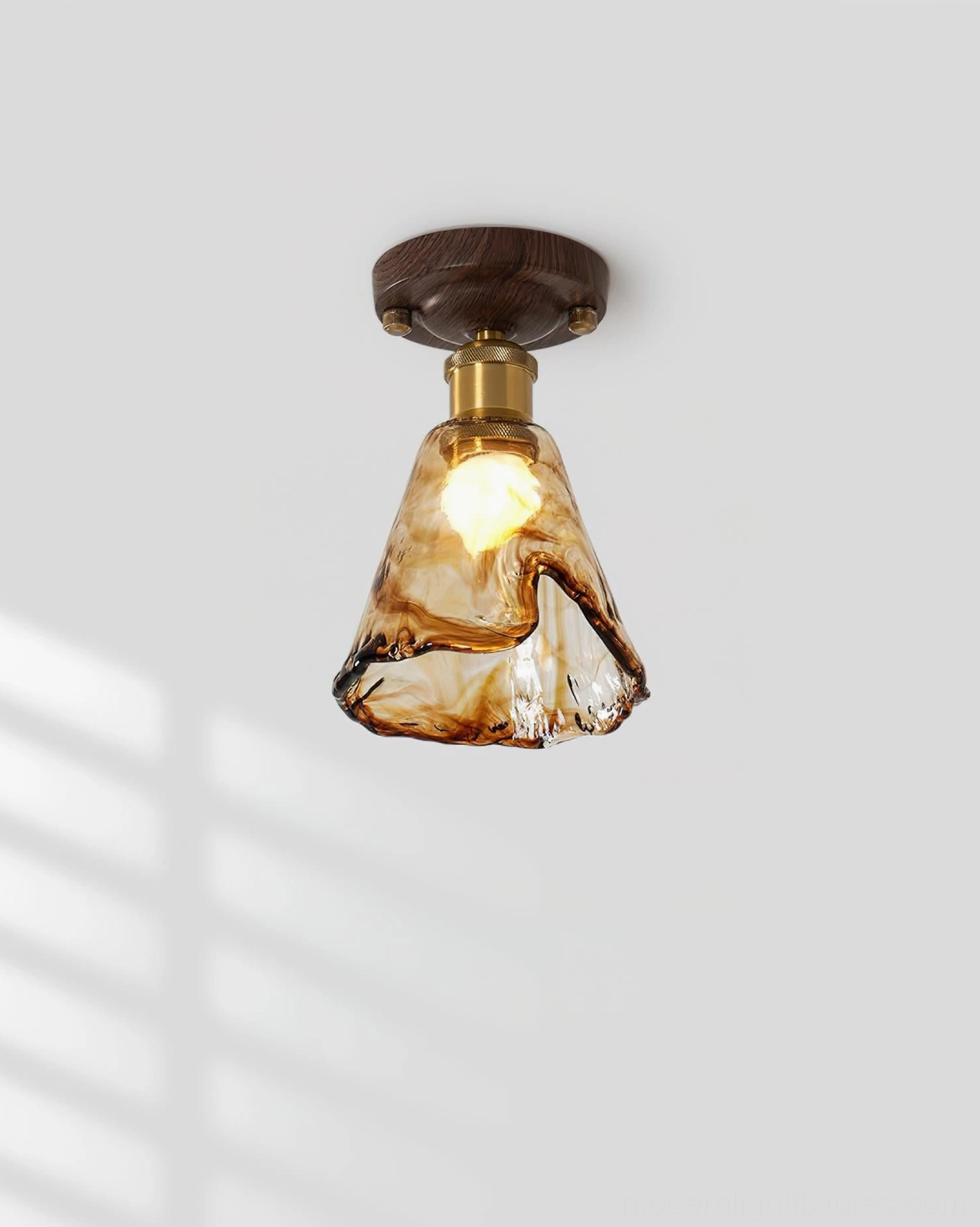 Textured amber glass shade of flush mount ceiling light - close-up showing hand-blown glass characteristics