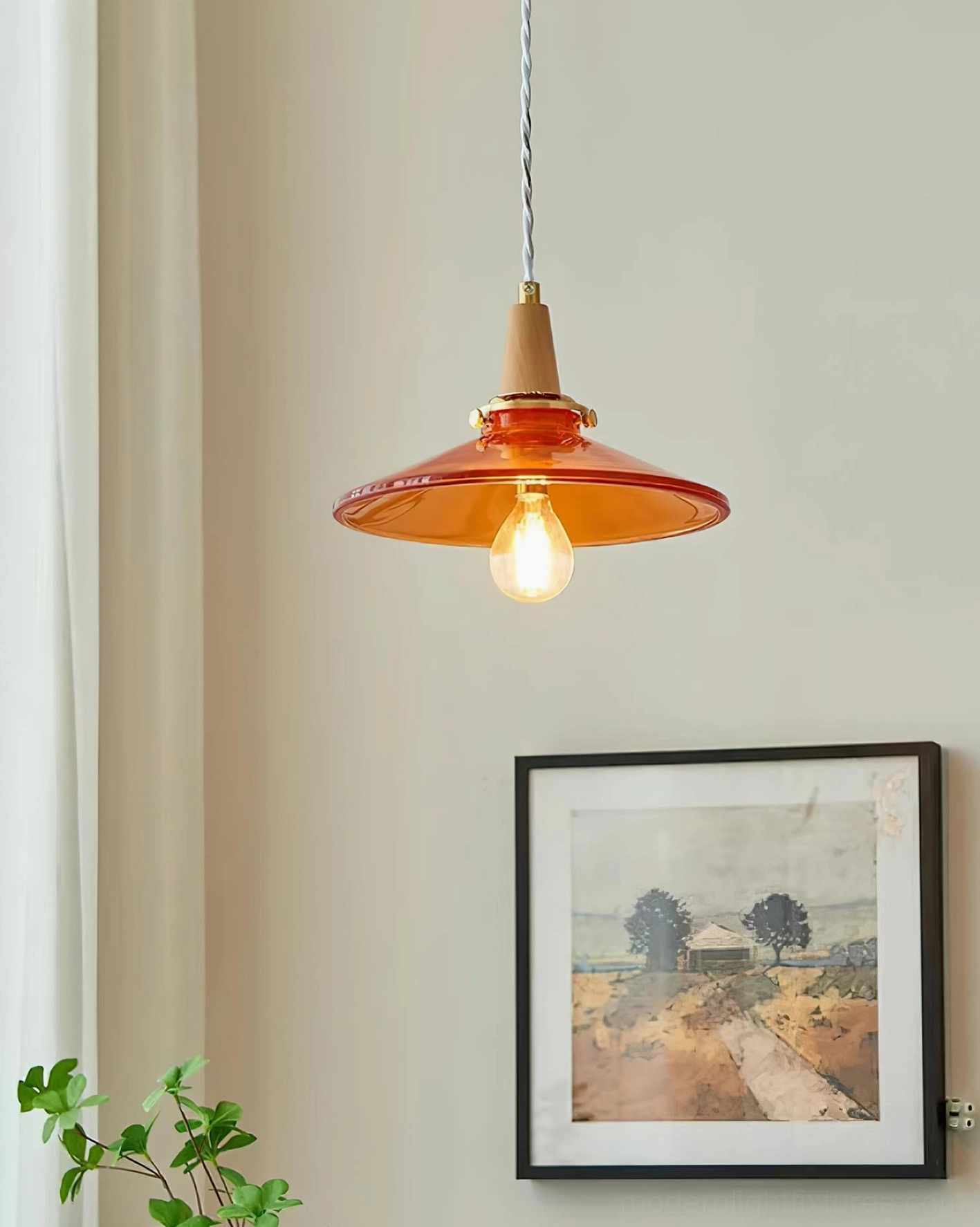 Amber glass pendant light fixture showing brass hardware, wood components, and warm lighting quality
