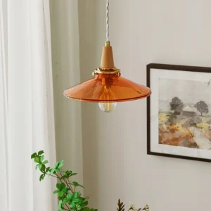 Amber glass pendant lamp installed in residential corner, showing warm glow with exposed Edison filament bulb