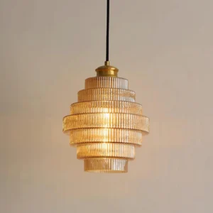 Close-up of amber tiered glass pendant lamp showing ridged surface texture and warm light refraction