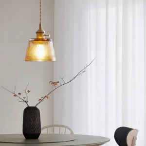 Amber glass pendant light installed above dining nook in residential interior