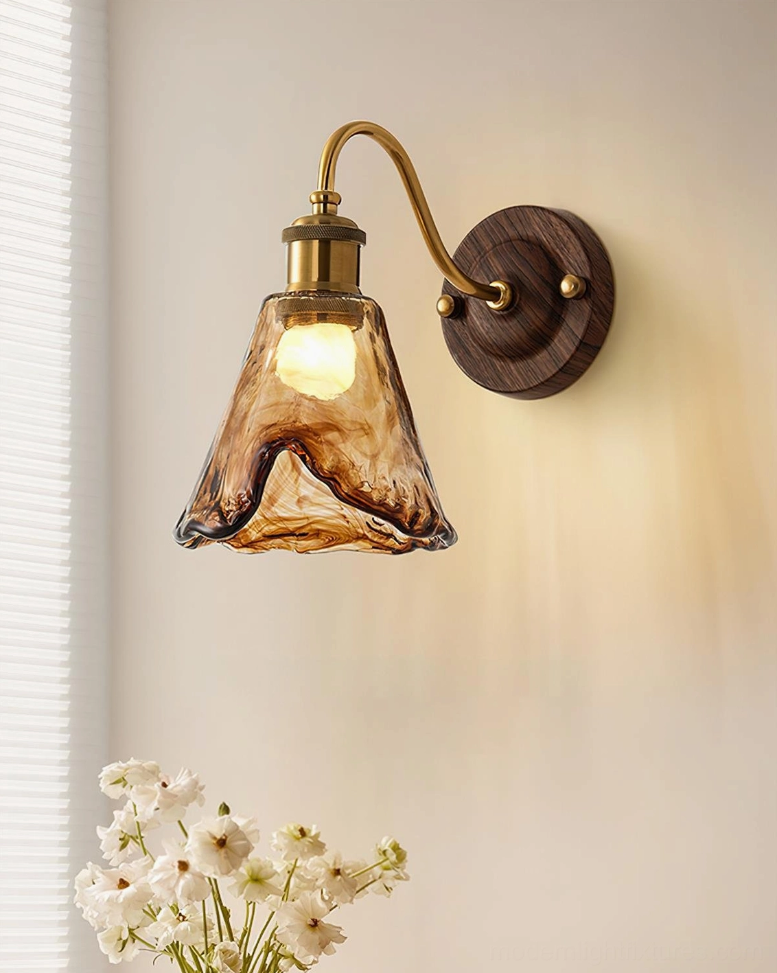 Modern amber glass wall lamp close-up side view showing rippled glass texture and brass hardware detail