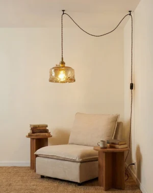 Retro amber glass swag pendant light installed in residential lounge nook, warm glow on neutral decor
