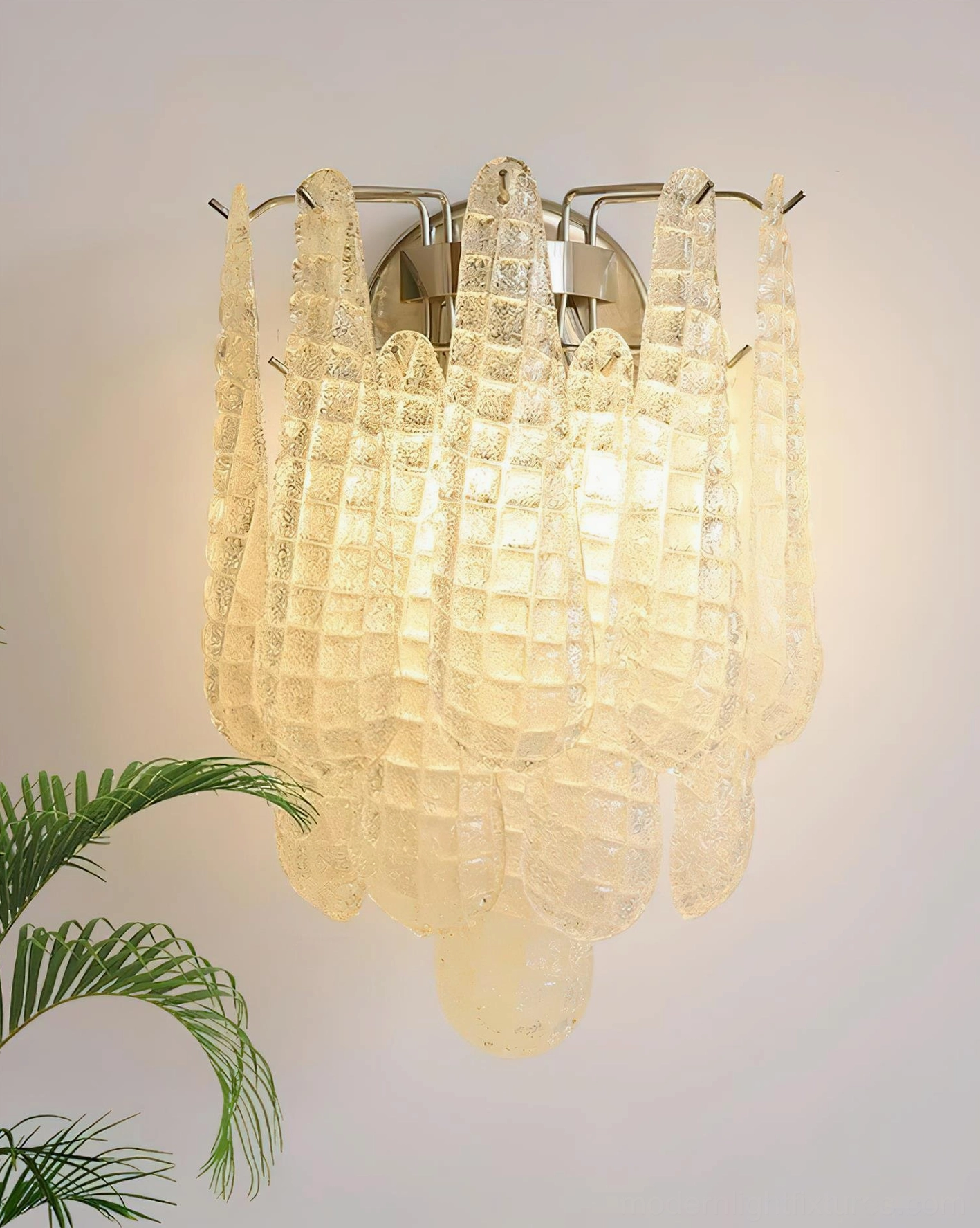 Warm-lit amber glass wall sconce with textured art glass and chrome hardware, close-up detail