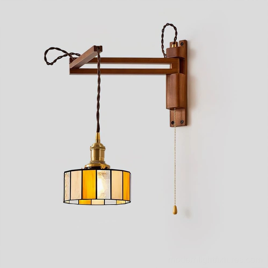 Amber and jade stained glass wall sconce creating warm ambient lighting in transitional home design space with modern furnishings and traditional glass artistry