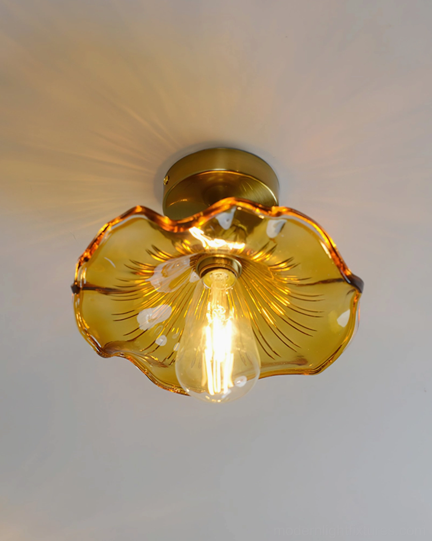 Amber ruffled glass semi-flush ceiling light with brass gold base, front overhead view