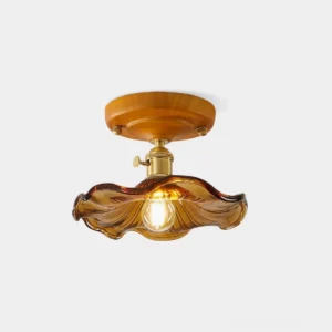 Amber ruffled glass flush mount ceiling light with wood canopy and brass fixtures, front view on white background