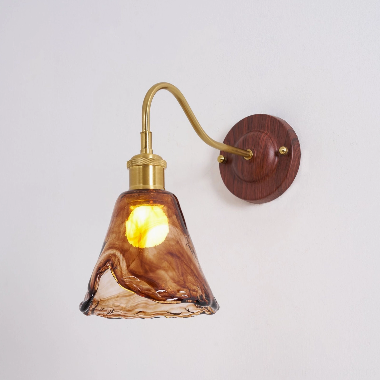 Contemporary wall sconce artistic photography emphasizing warm amber glow and shadow interplay