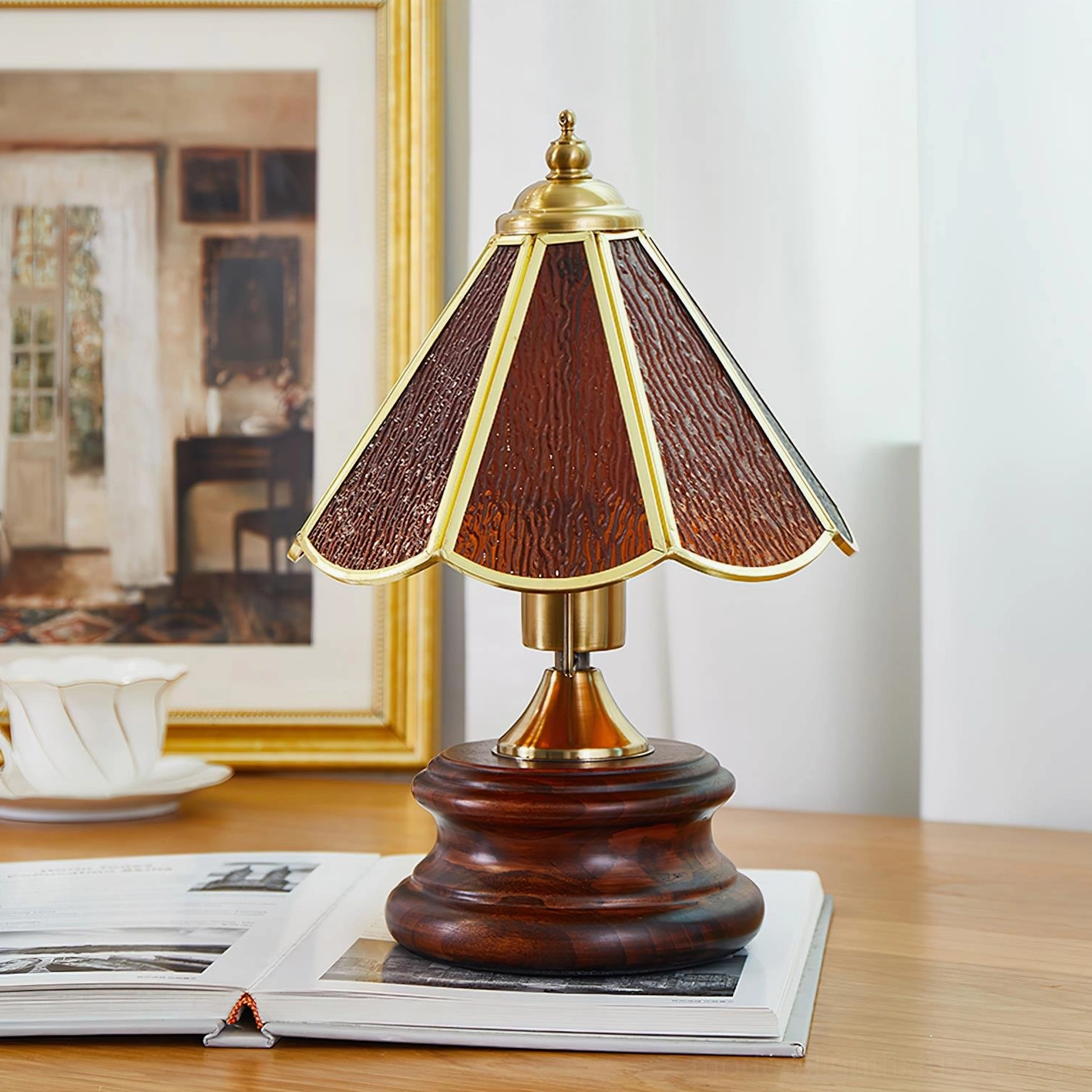 Walnut color amber stained glass table lamp with wood grain panels and brass trim on wooden base, three-quarter desk view