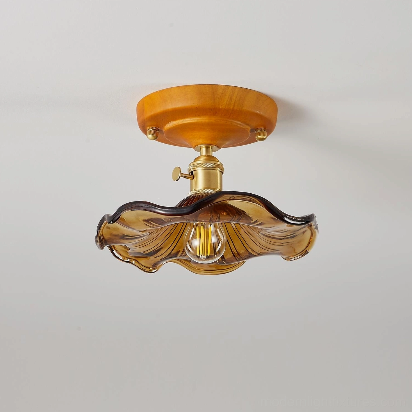 Amber textured glass flush mount ceiling light with warm glow, studio product photography