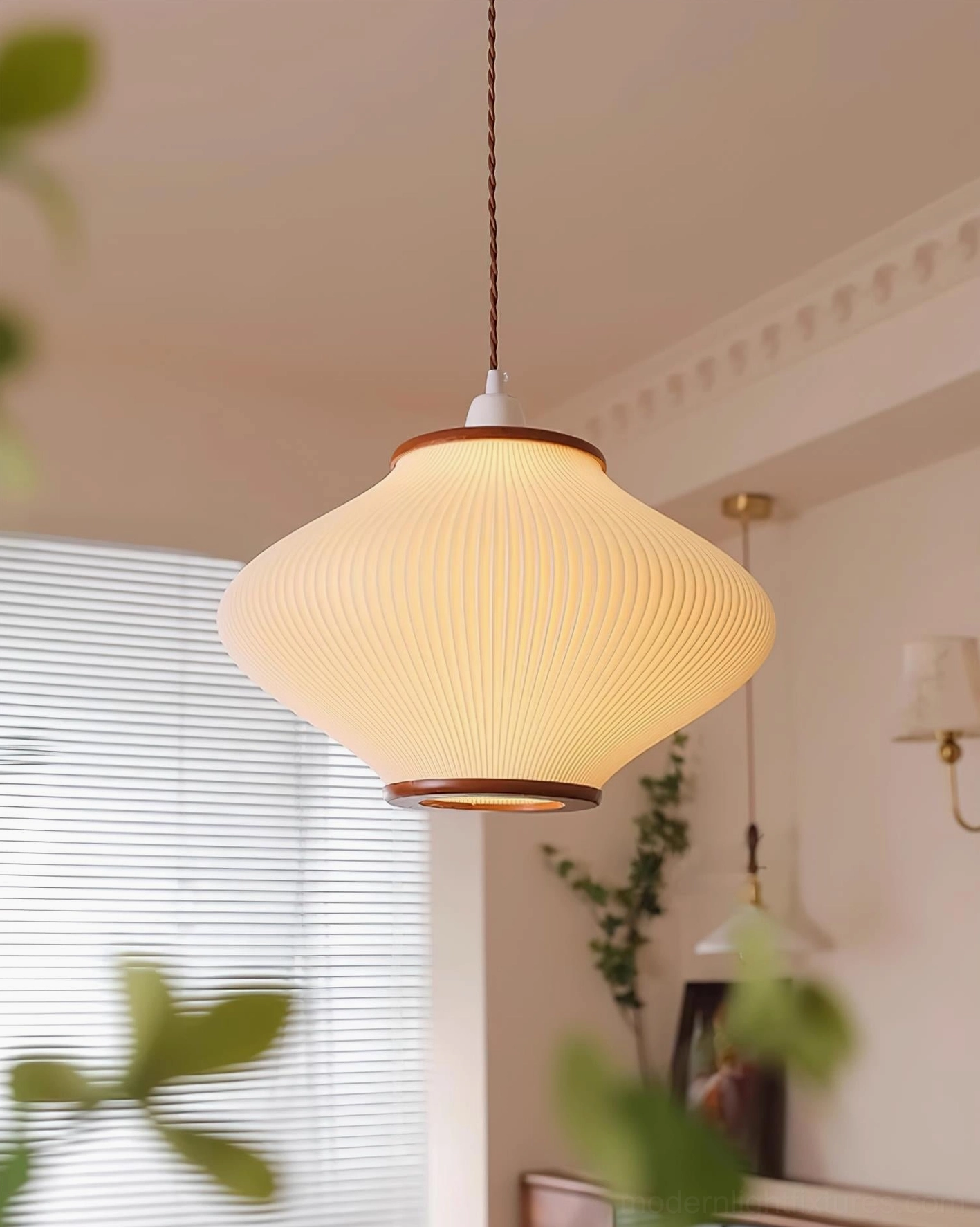 Japanese-inspired pendant lamp creating soft ambient light in cozy residential living space with window treatments
