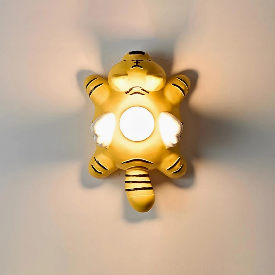Cute cartoon animal wall sconce with glowing warm light on dark wall