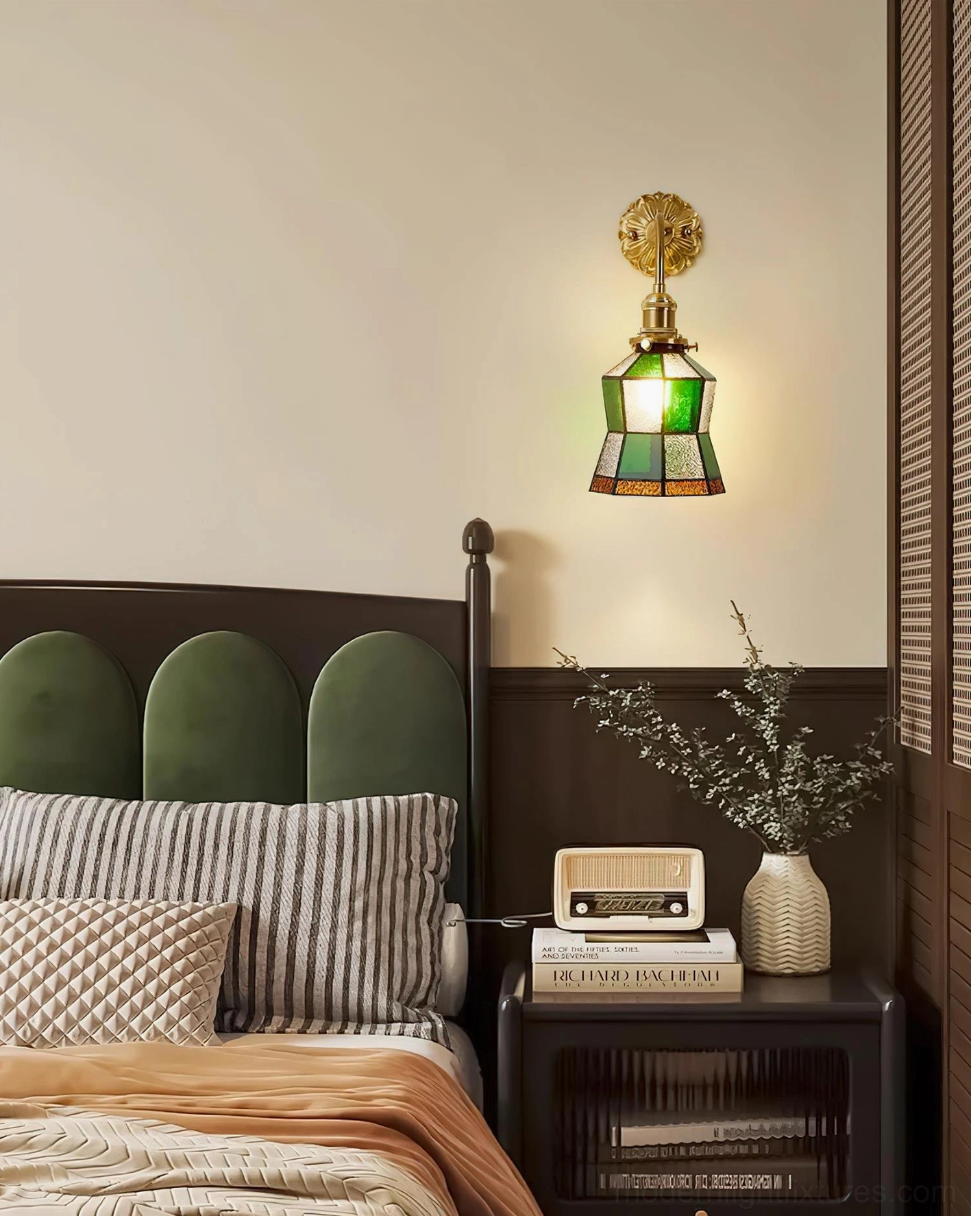 Illuminated stained glass wall sconce mounted above upholstered bed headboard in vintage bedroom interior, side view showing glass light diffusion