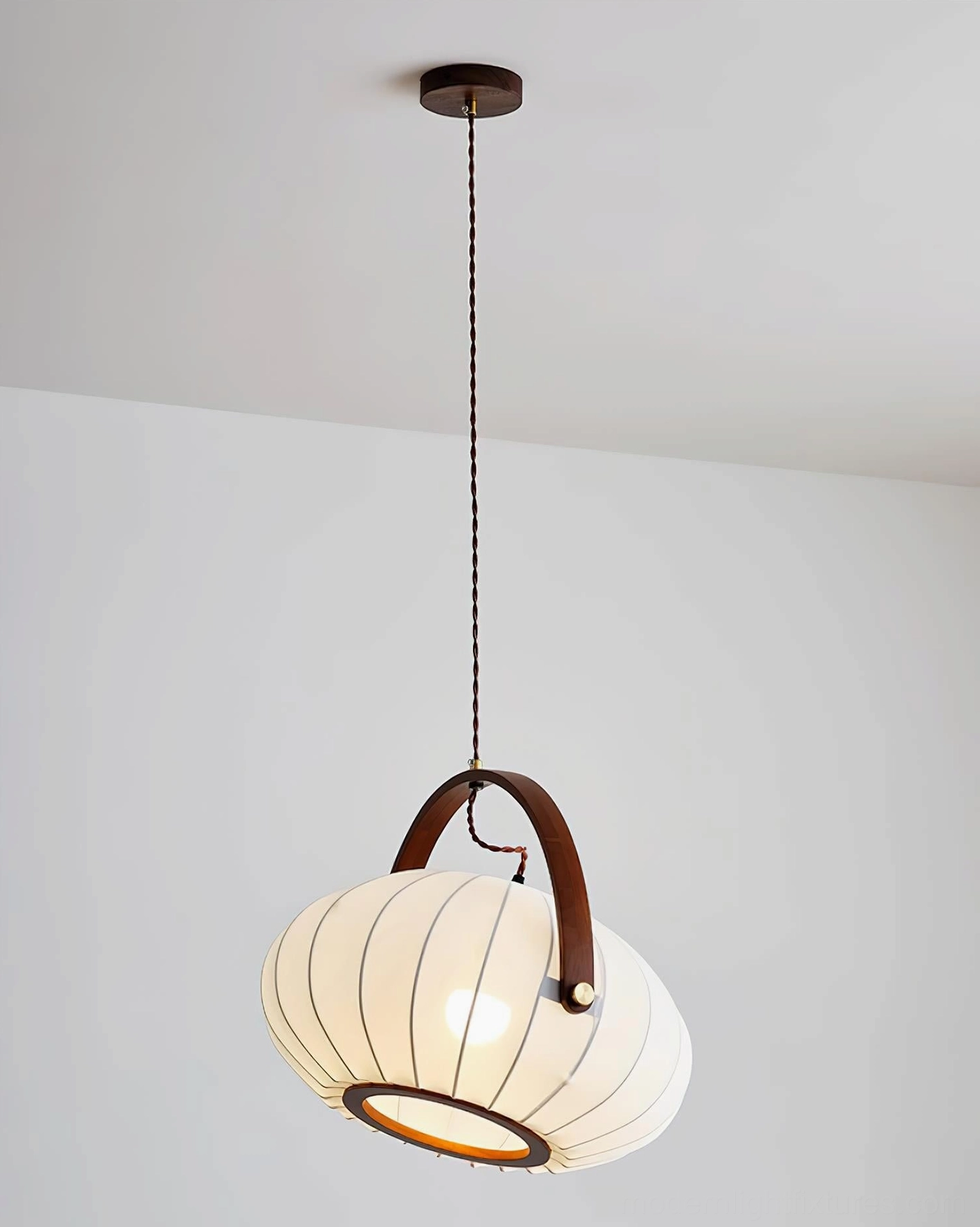 Front overhead view of pendant lamp with long adjustable hanging cord and dark wood accent handle