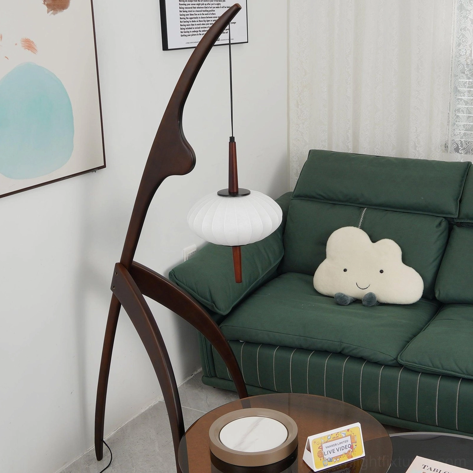 Contemporary arc floor lamp with curved wooden stand and soft fabric lantern illuminated