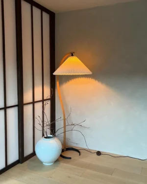 Arc floor lamp in Japanese-style room with ceramic vase, warm ambient lighting from pleated shade