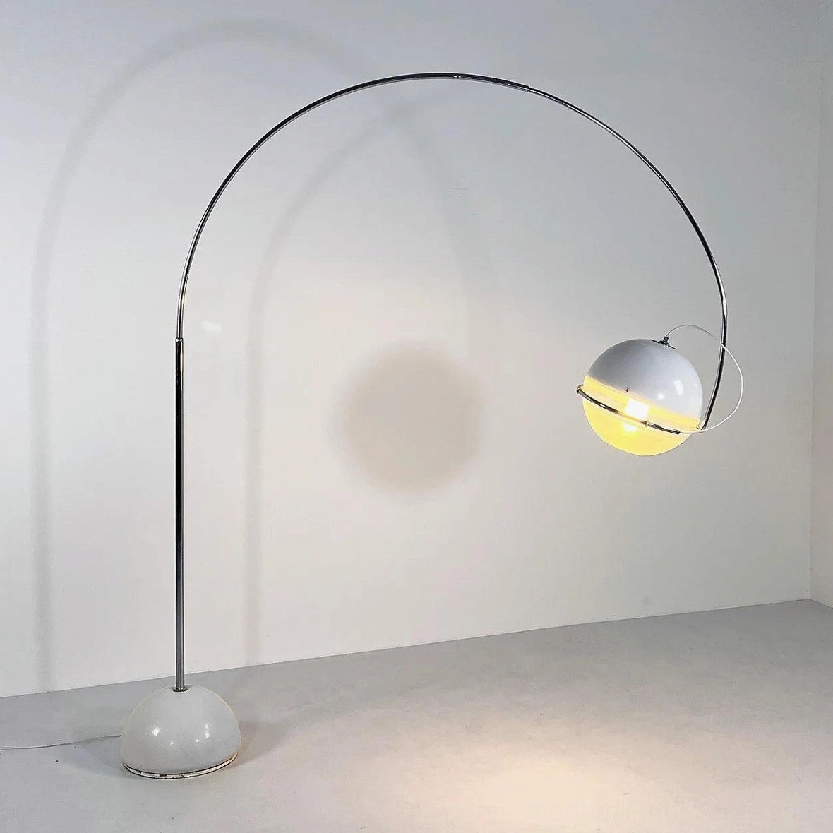 Arc floor lamp left side studio view with illuminated spherical shade showing light diffusion