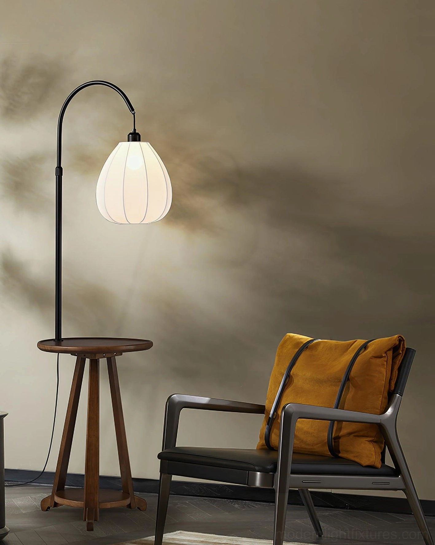 Arc floor lamp with wooden table in living room setting, black accent chair, yellow throw pillow, warm interior design