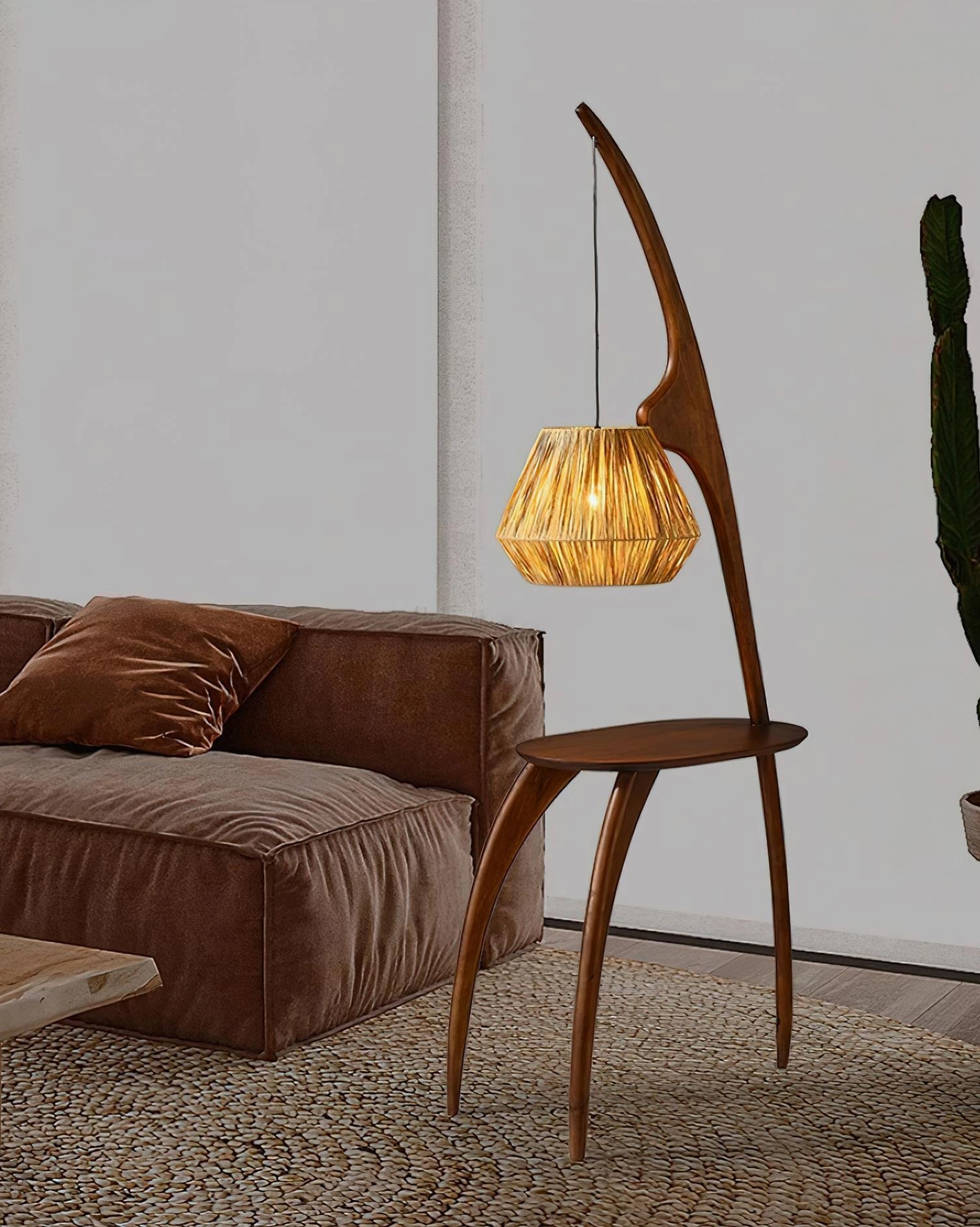 Arc floor lamp beside brown sofa with tall plant, warm indoor ambient lighting in living room