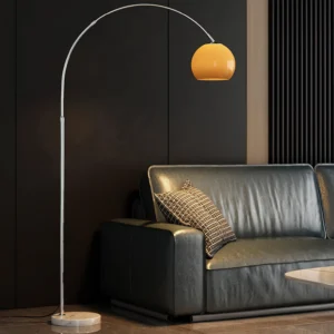 Contemporary arc floor lamp in living room setting with sofa, chrome arched pole and warm orange lampshade