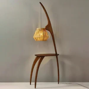 Arc floor lamp with side table, warm glowing rattan shade, three-quarter view with power cord visible