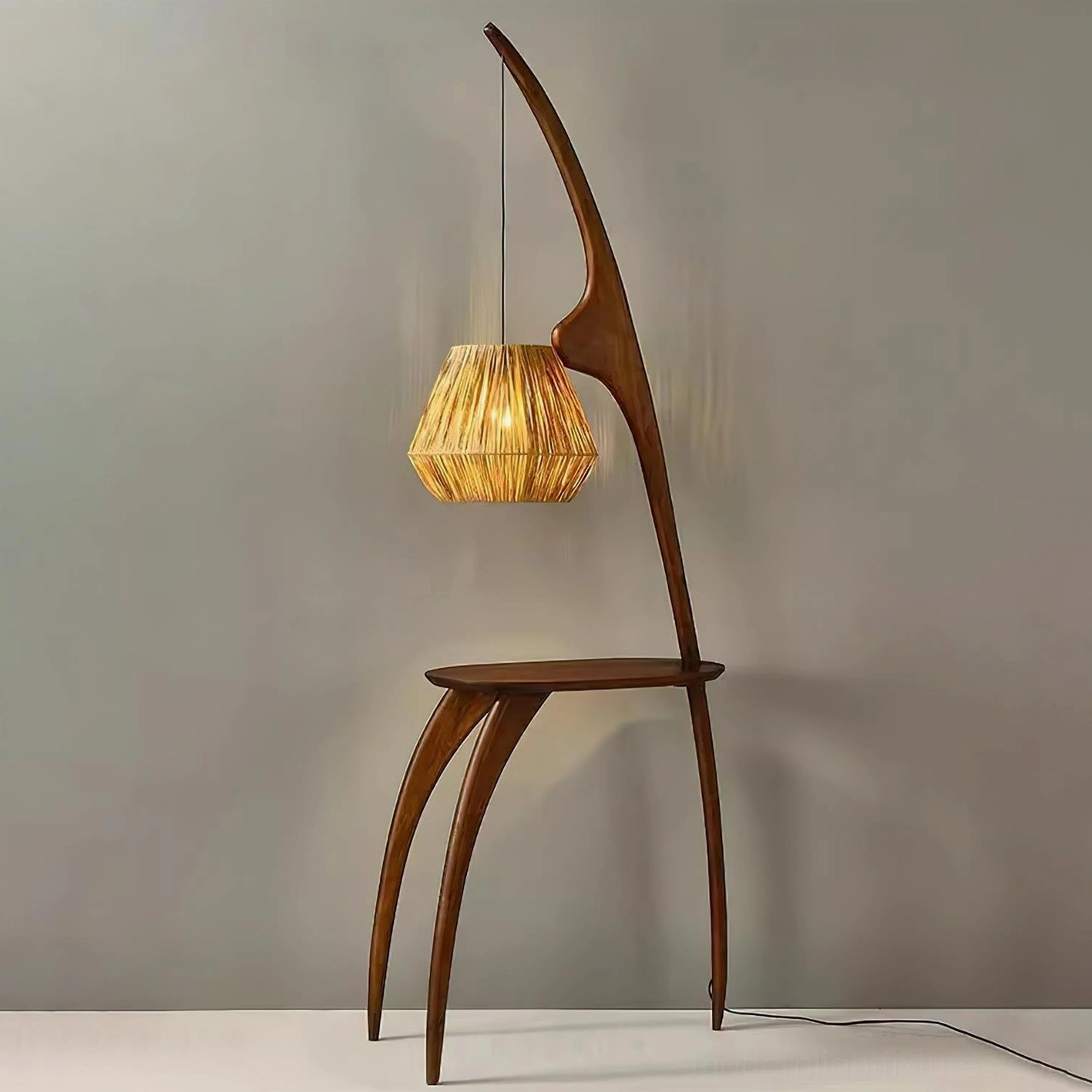 Arc floor lamp with side table, warm glowing rattan shade, three-quarter view with power cord visible