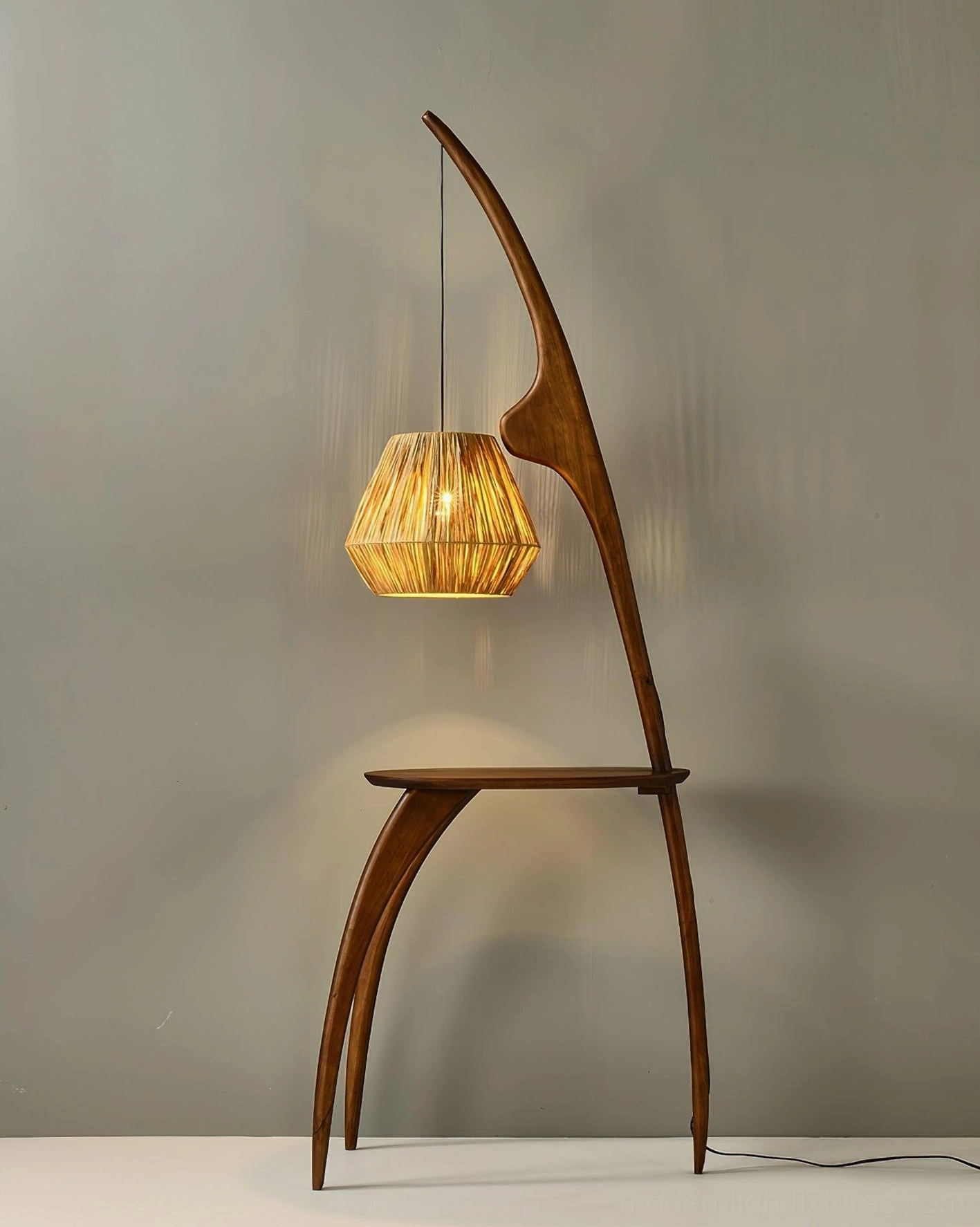 Arc floor lamp rear view with walnut wood base, rattan lampshade, visible cord on grey background