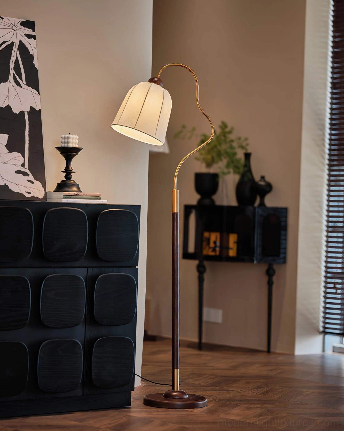 Arc floor lamp in living room with dark decorative cabinet, walnut brown pole with brass accent and curved metal arm