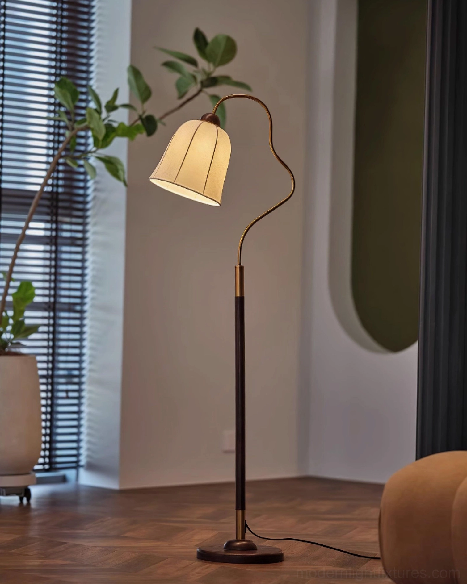 Arc floor lamp in living room with potted green plant, walnut brown metal pole and round wooden base
