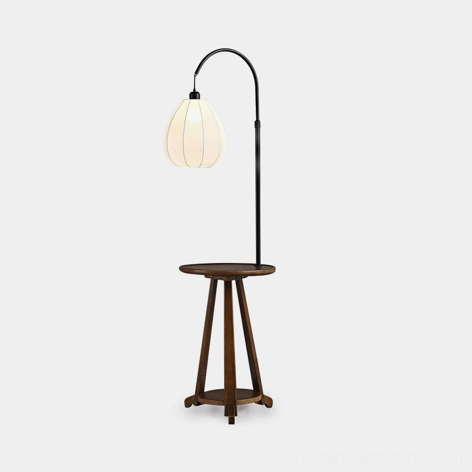 Arc floor lamp with wooden side table, black metal frame, fabric shade, white studio background - modern lighting fixture