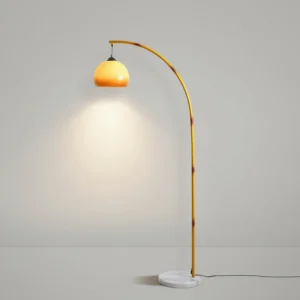 Contemporary arc floor lamp with light yellow curved metal frame and warm caramel dome shade - product showcase with ambient lighting