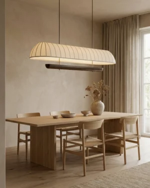 Arcelle linear chandelier installed over wooden dining table in modern residential dining room, warm integrated LED light casting soft glow over table setting and walnut wood furniture