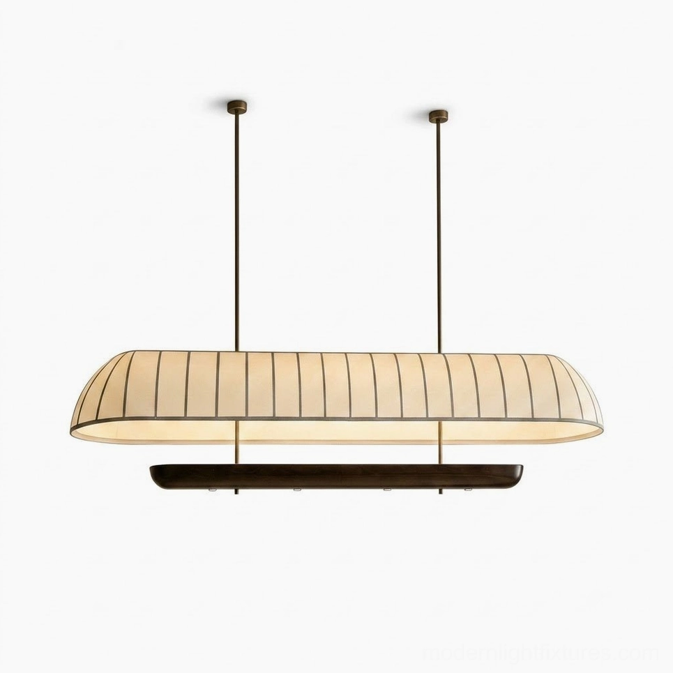 Arcelle oblong pill-shape pendant light showing smaller size variants mounted in residential settings, cream fabric shade with walnut base in warm contemporary interiors