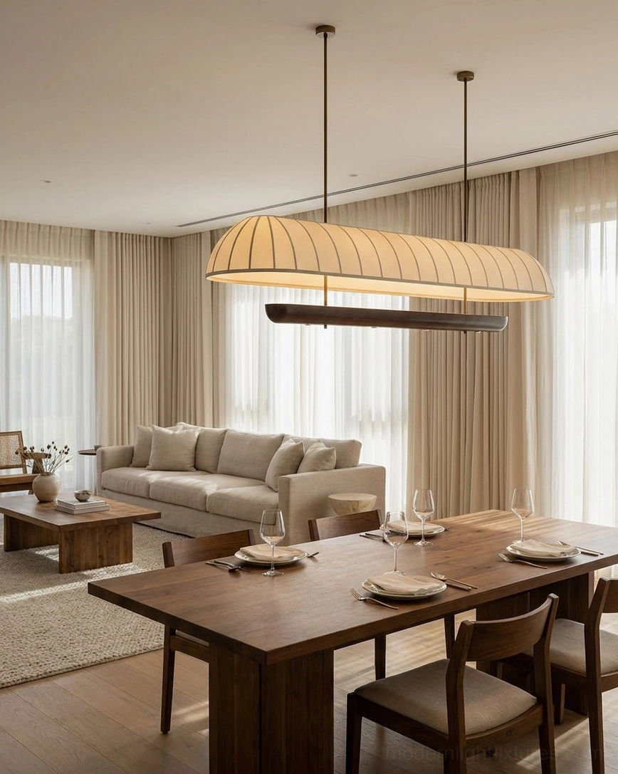 Arcelle linear chandelier in open-concept living and dining area with modern linen sofa, warm neutral fabric shade casting ambient glow over combined residential space