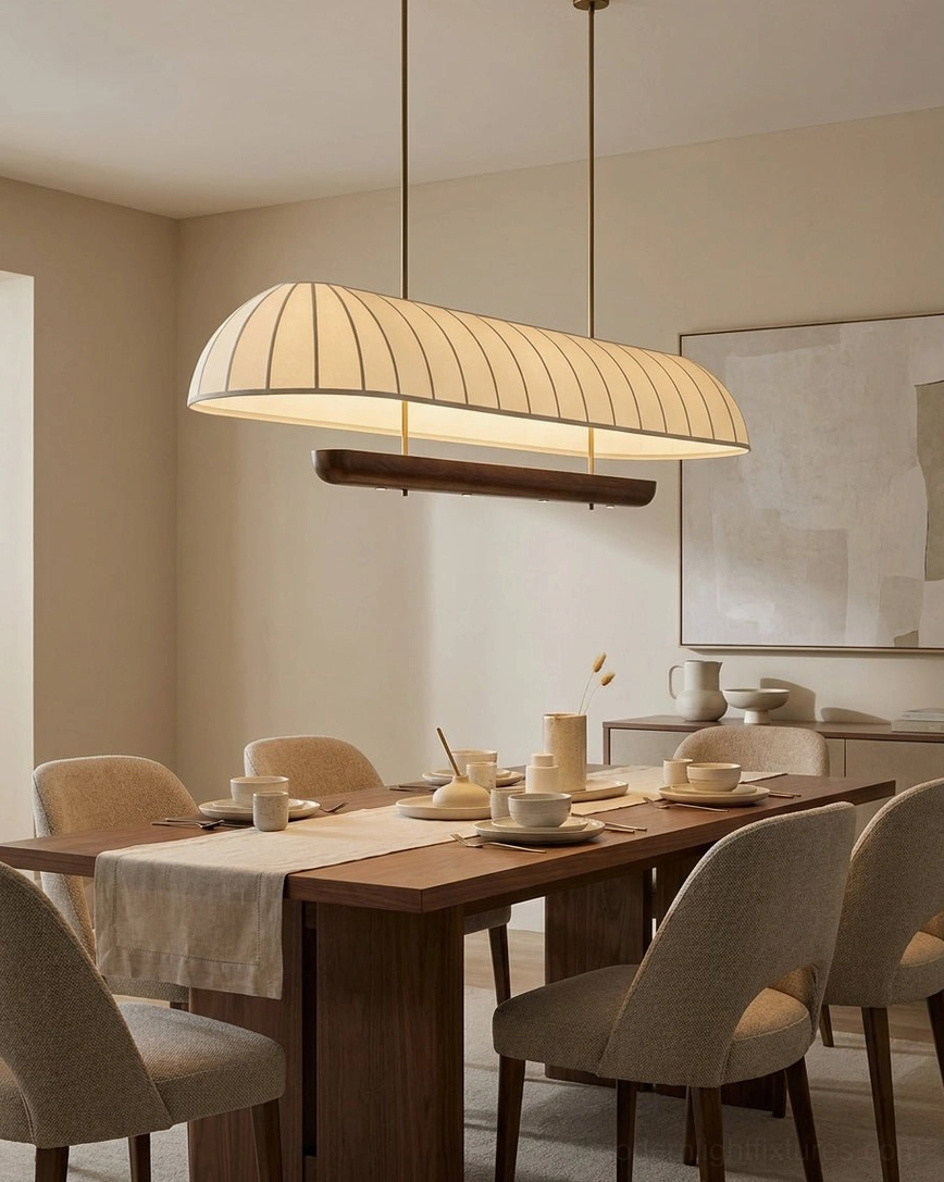 Arcelle pill-shape chandelier in contemporary dining area with minimalist styling, warm cream shade with vertical pleats creating subtle shadow play on ceiling and table surface