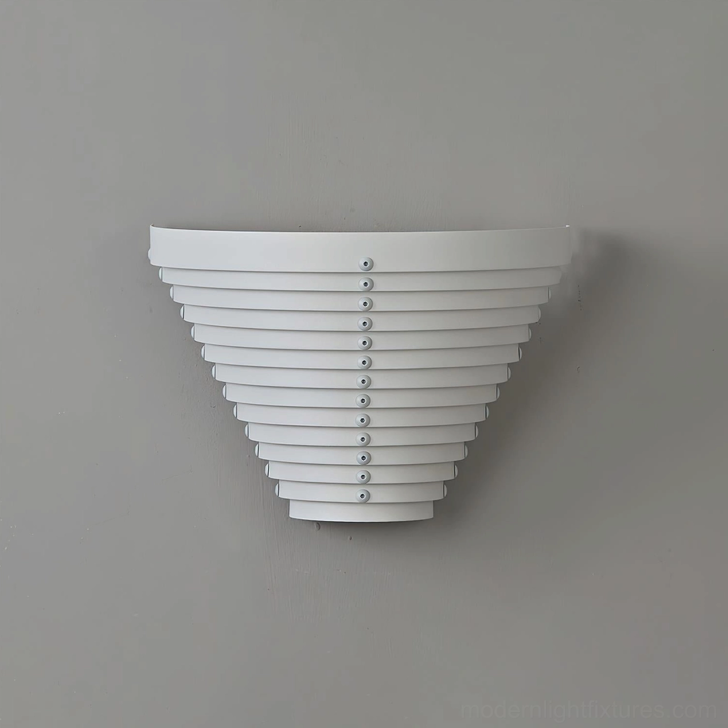 Modern geometric louvered white wall sconce, side angle view showing sculptural cone form and mounting