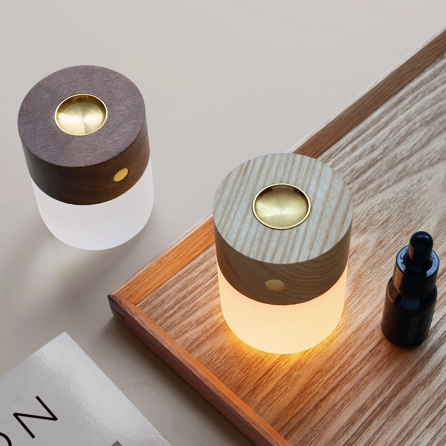 Overhead view of aroma diffuser night lights with one emitting water vapor on wooden tabletop