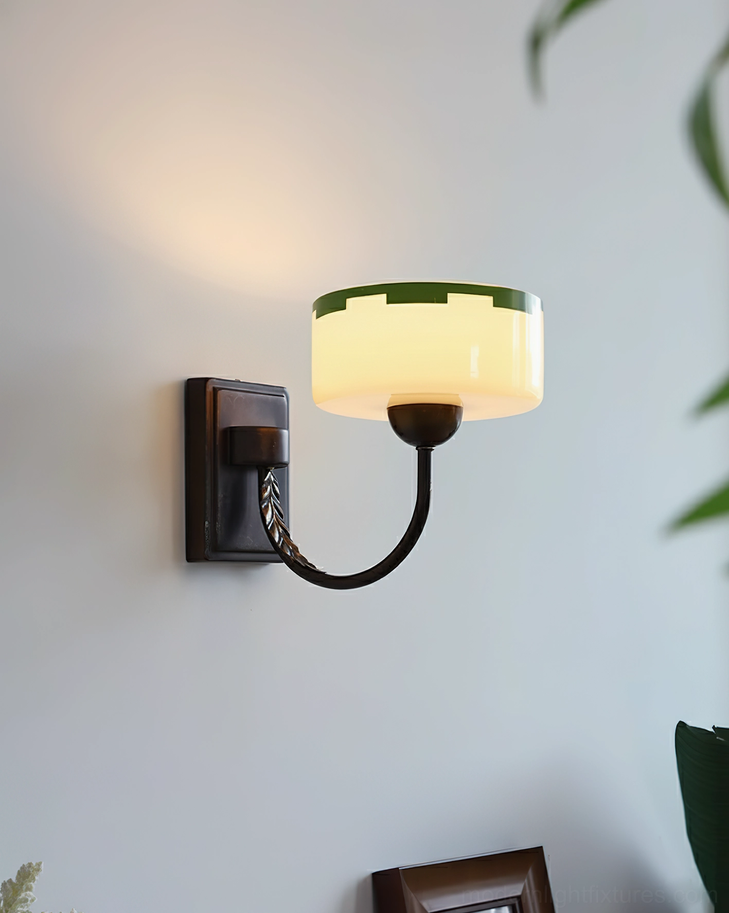 Art Deco wall sconce with green-trimmed shade mounted on gray wall, twisted metal arm design